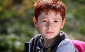 crianca ruiva sentada